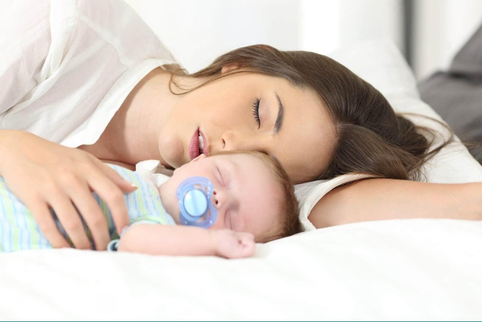 Mãe Cansado Que Dorme Com Seu Bebê Imagem de Stock